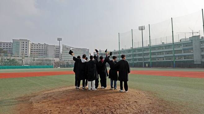 마지막 졸업식을 마친 덕수고등학교 야구부 졸업생들이 지난 5일 마운드 위에서 기념촬영하고 있다 / 연합뉴스
