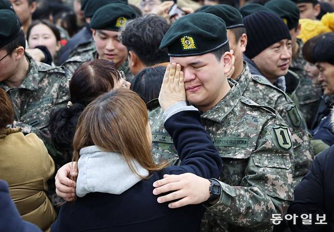 육군 제1보병사단 신병교육대대의 마지막 수료식이 열린 31일 오전 경기도 파주시 문산읍 1사단 신병교육대대에서 강태현 훈련병이 어머니가 계급장과 사단 마크를 달아주자 눈물을 흘리고 있다. 군 당국은 지난해 12월 입영 자원 감소로 인한 군 구조 개혁의 일환으로 서부전선을 지키는 1군단 예하 사단 신교대를 전부 해체하기로 했다. 이에 따라 올해 1월부터 1·9·25사단 신교대의 임무가 해제된다. 박형기 기자 oneshot@donga.com