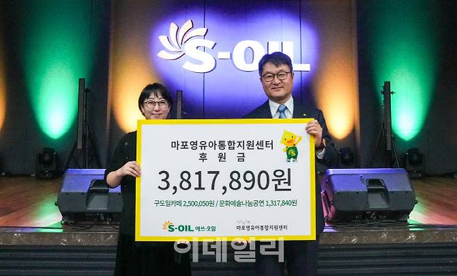 S-OIL 김광남 부문장(오른쪽)과 마포영유아통합지원센터 시소와그네 임명연 관장(왼쪽)이 31일 서울 마포구 S-OIL 본사에서 열린 ‘구도일 카페 및 문화나눔공연 모금액 전달식’에서 기념사진을 찍고 있다.