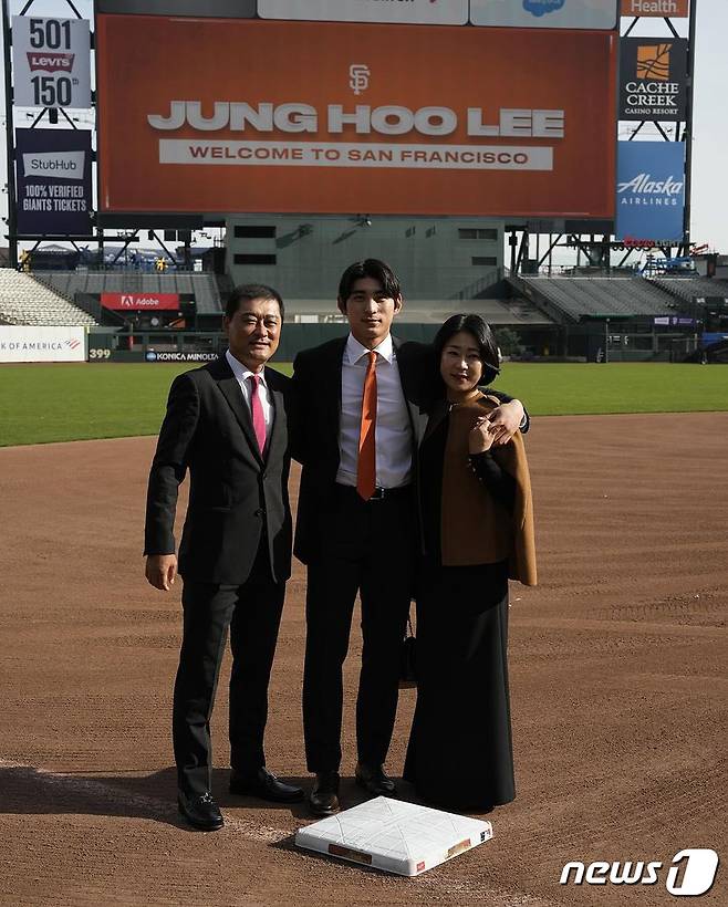 메이저리그(MLB) 샌프란시스코 자이언츠의 유니폼을 입은 이정후가 15일(현지시간) 미국 캘리포니아주 오라클파크에서 열린 입단식에서 아버지 이종범 전 LG트윈스 코치, 어머니 정현희씨와 함께 기념촬영을 하고 있다. (샌프란시스코 자이언츠 SNS)2023.12.17/뉴스1