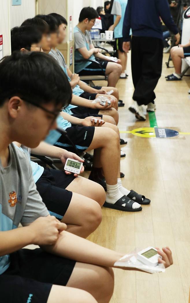 채혈 후 잠시 쉬는 대상 청년들. 손에 쥐고 있는 건 타이머입니다. 타이머가 꺼질 때까지 채혈 주사를 꽂았던 자리를 알콜 솜으로 꾹!