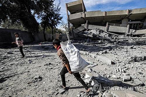 가자지구에서 UNRWA 적힌 봉지 들고가는 소년 [AFP=연합뉴스 자료사진]