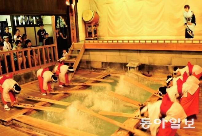 구사쓰 온천의 원천수에 긴 나무판을 넣어 휘저으며 식히는 ‘유모미’.