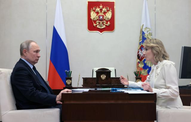 블라디미르 푸틴(왼쪽) 러시아 대통령이 지난해 2월 마리아 르보바 벨로바 러시아 아동인권위원과 회의를 하고 있다. 국제형사재판소(ICC)는 지난해 3월 우크라이나 아동들을 러시아로 납치한 '전쟁 범죄' 혐의로 두 사람의 체포 영장을 발부했다. EPA 연합뉴스