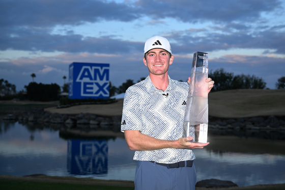 Nick Dunlap of the United States poses for a photo with the trophy after winning The American Express at Pete Dye Stadium Course on Jan. 21 in La Quinta, California. [GETTY IMAGES]
