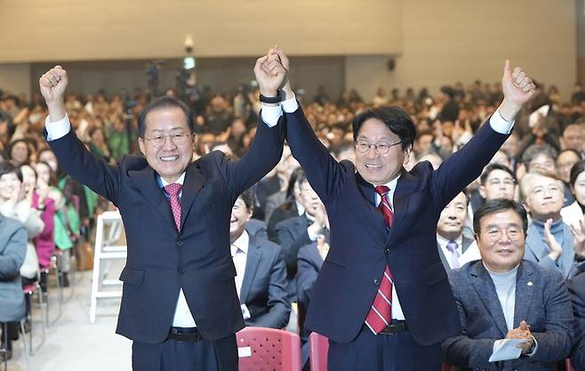 7일 오후 광주 김대중컨벤션센터에서 열린 ‘달빛철도 특별법 국회통과 축하행사’에서 강기정 광주시장(오른쪽)과 홍준표 대구광역시장이 손을 맞잡고 환호하고 있다.