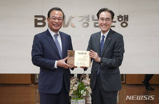 [창원=뉴시스]BNK경남은행 예경탁 은행장(오른쪽)이 경남사회복지공동모금회 강기철 회장으로부터 ‘나눔명문기업 인증패’를 전달받고 있다.(사진=BNK경남은행 제공)2024.02.07. photo@newsis.com