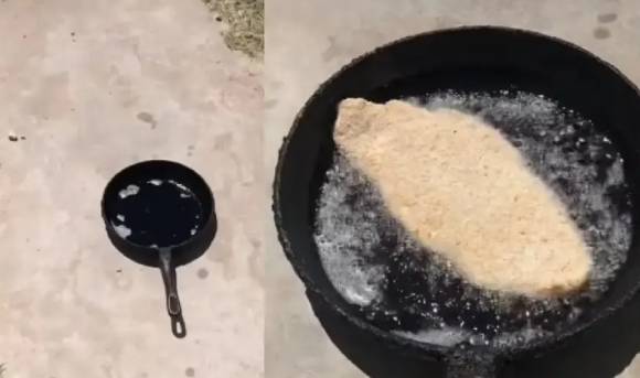 사진=아스팔트 위에서 달아오른 프라이팬에서 고기가 튀겨지고 있다.