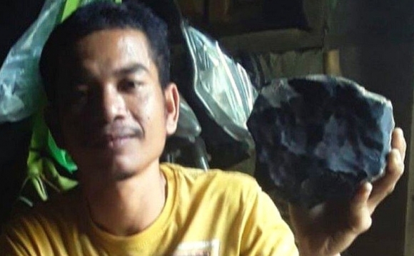 조슈아 후타가룽이 인도네시아 수마트라섬의 자기 집 마당에서 발견한 운석을 들고 있다. 속아서 20억짜리를 1600만원에 팔았다.