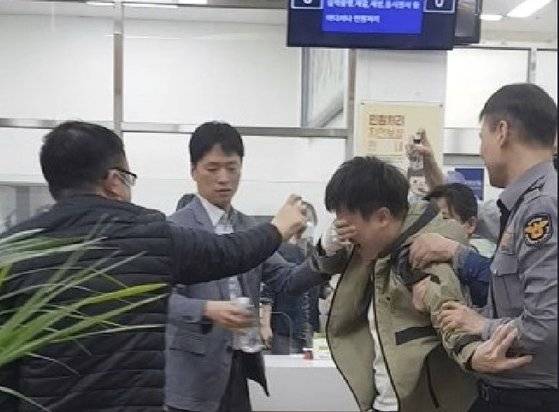 지난해 4월 26일 부산시청 2층 행복민원실에서 난동을 부리던 A씨가 얼굴에 호신용 스프레이를 맞고 괴로워하고 있다. 이 상황은 민원인 폭력행위 대응 모의 훈련에서 연출됐다. 사진 부산시