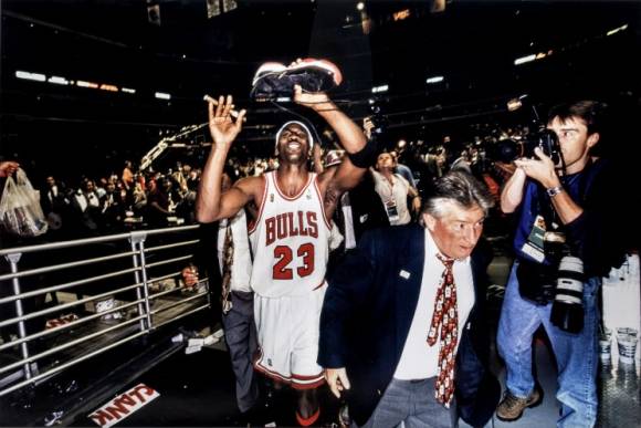 마이클 조던이 1996년 챔피언결정전에서 신었던 에어 조던 11 브레드 농구화 한 짝을 벗어들고 있는 모습. / 사진=소더비