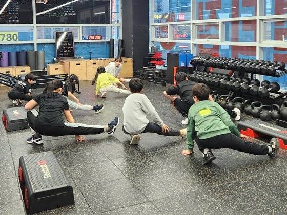 부산 팀폭스멀티짐에서 학생들이 스트레칭을 하고 있다. 교실에는 근력 운동에 쓰이는 덤벨과 바벨 등이 놓여 있다. 사진 독자제공