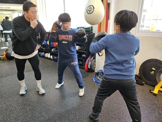 유정우 서울 WE복싱짐 관장이 초등학생들을 가르치고 있다. 짝을 정해서 주먹을 지르거나 피하는 연습을 하고, 혼자서 샌드백을 치기도 한다. 사진 독자제공
