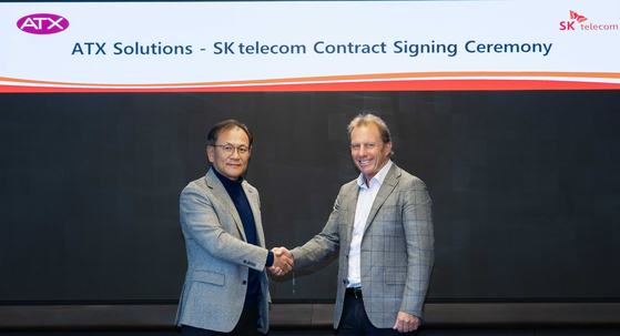SK Telecom Chief Development Officer Ha Min-yong, left, and ATX Medical Solutions founder Roger Davis shake hands after signing a deal to distribute SK Telecom's X Caliber in the Australian market. [SK TELECOM]