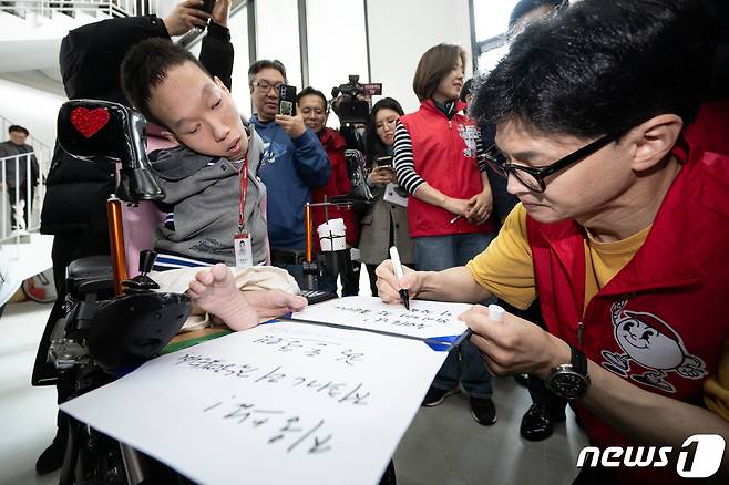 한동훈 국민의힘 비상대책위원장이 14일 서울 은평구 다다름하우스에서 열린 자립준비쳥년 지원주택 현장간담회에 참석하기에 앞서 유태호 다다름 공간매니저에게 친필 서명을 해주고 있다.  (공동취재) 2024.2.14/뉴스1 ⓒ News1 송원영 기자