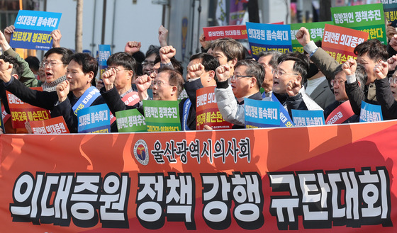 Doctors protest the government plan to expand medical school admissions before the People Power Party's office in Ulsan on Thursday. [YONHAP]