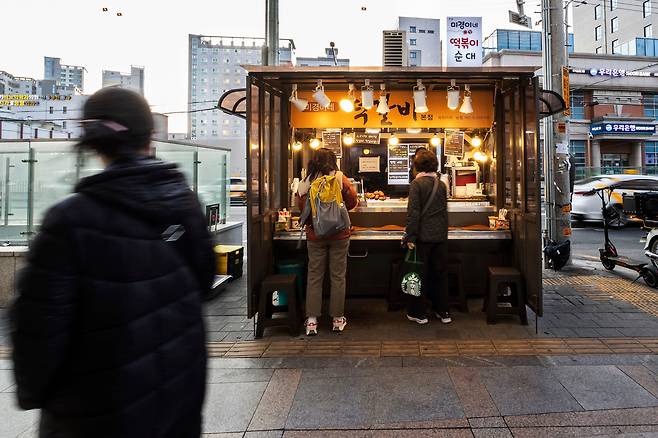 신림역 인근 한 먹거리 노점. 이어폰을 꽂은 채 스마트폰을 들여다보며 묵묵히 혼자 식사하는 이들이 주고객이다. /양수열 영상미디어 기자