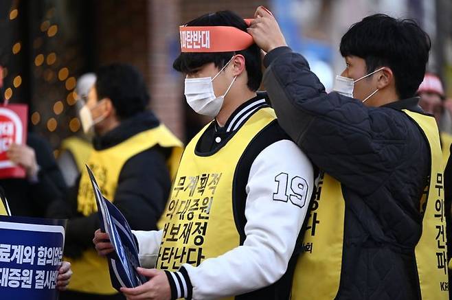 지역 의대생들이 15일 오후 광주 서구 국민의힘 광주시당 앞에서 열린 '윤석열 케어 규탄 대회'에 참여해 서로의 머리띠를 묶어주고 있다.ⓒ뉴시스