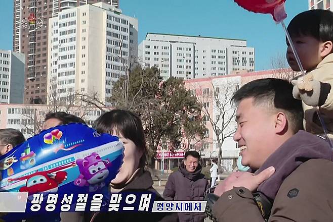 북한 조선중앙TV가 지난 16일 평양시 공연 소식을 전하던 화면. 아이를 대동한 한 관객이 든 풍선에 한국 애니메이션 캐릭터가 그려져 있다. /조선중앙TV 연합뉴스