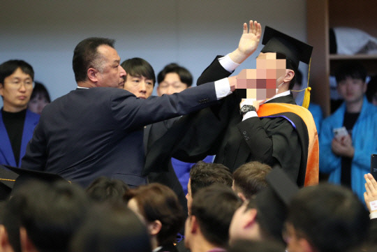 16일 오후 2시 한국과학기술원 대전 본원에서 열린 학위수여식에서 한 졸업생이 경호원에 의해 제지당하고 있다. 이 학생은 KAIST 졸업생이자 녹색정의당 대전시당 대변인으로 밝혀졌다. 사진=대전충남공동취재단 제공