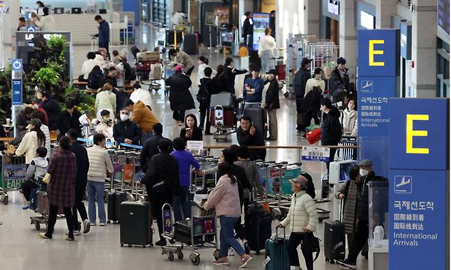 설 연휴 마지막 날이었던 지난 12일 인천국제공항 제1여객터미널 입국장이 해외여행을 다녀온 여행객들로 붐비고 있다. 뉴시스