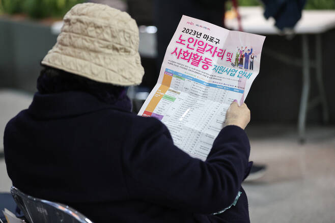 한 시민이 서울 마포구청에서 열린 노인 일자리 박람회에서 안내문을 읽고 있다. 연합뉴스