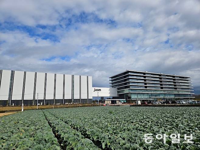 15일 일본 구마모토현 기쿠요정에 들어선 대만 반도체 기업 TSMC 공장 전경. 양배추밭 옆에 지어진 공장 외벽에 일본 현지법인명 ‘Jasm’이 적힌 간판이 걸렸다. 이곳에는 소니, 도쿄일렉트론 등 일본 유수의 반도체 관련 기업들이 몰려 있다. 구마모토=이상훈 특파원 sanghun@donga.com