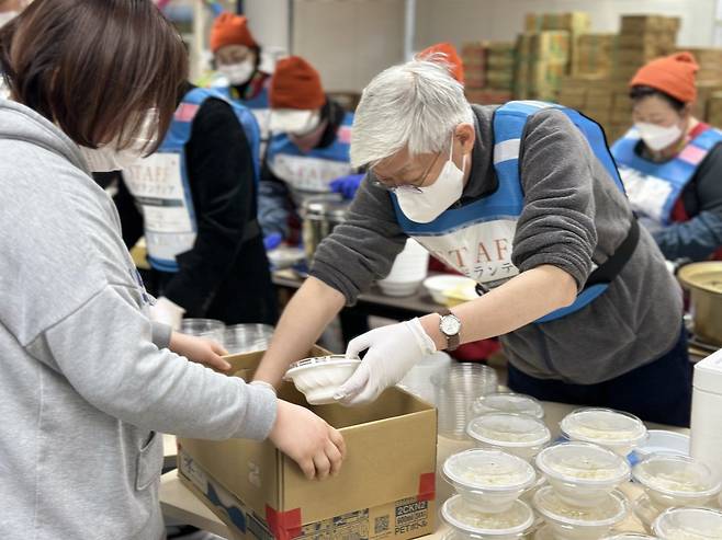 윤덕민 주일 한국대사(오른쪽)가 20일 이사카와현 나나오시에서 지진 피해자들에게 나눠줄 음식을 담고 있다. 주일본 한국대사관 제공