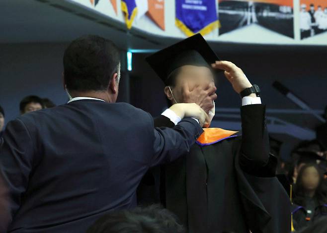 한국과학기술원(KAIST) 신민기씨가 지난 16일 열린 2024년 학위수여식에서 윤석열 대통령 축사 중 R&D 예산을 두고 항의하다 경호원들에게 제지당하고 있다. 대통령실통신사진기자단