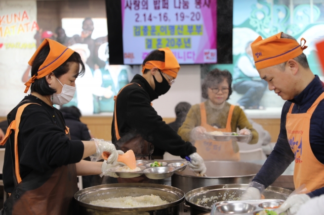 김종운(오른쪽) 이명신(왼쪽) 부부가 20주년 결혼기념일인 지난 14일 서울 동대문구 밥퍼나눔운동본부에서 배식 봉사를 하고 있다. 밥퍼나눔운동본부 제공