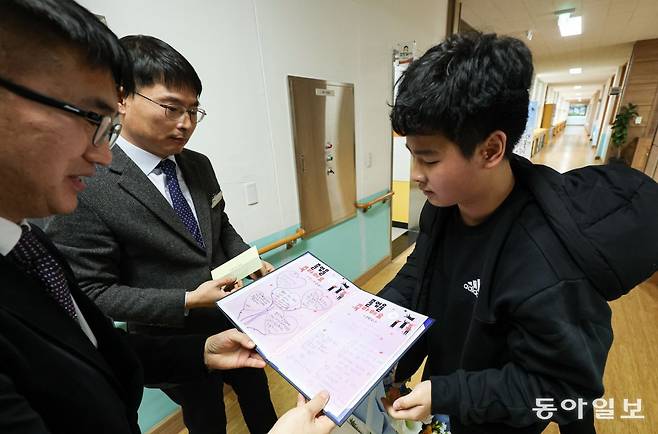 21일 오전 경상남도 밀양시 태룡초에서 열린 제96회 졸업장 수여식에서 졸업생 김준호 군(13)이 재학생들과 선생님들이 만든 롤링 페이퍼를 받고 있다. 밀양=이한결 기자 always@donga.com