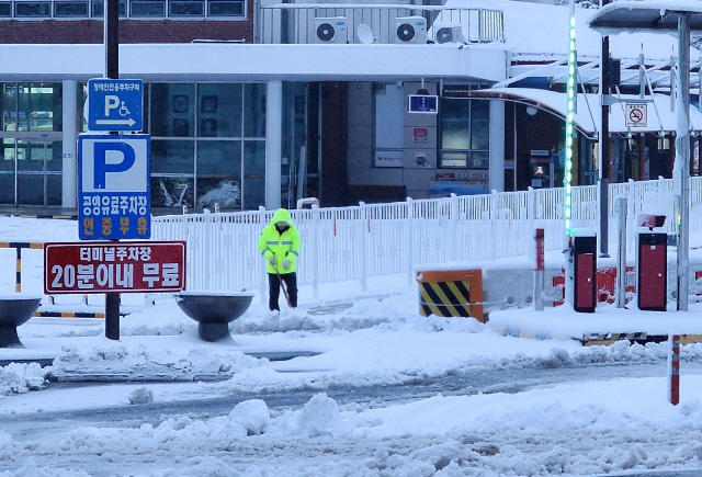 ▲ 22일 동해시 평릉동 동해종합버스터미널에서 직원이 눈을 치우고 있다.