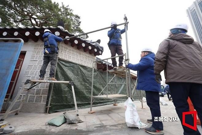 경복궁 담장 낙서 제거 작업이 마무리된 4일 문화재청 관계자들이 서울 종로구 경복궁 담장의 가림막을 걷어 내고 있다. 세척과 색 맞춤 등 복원을 마친 담장은 이날부터 일반인들에게 공개된다. 사진=조용준 기자 jun21@