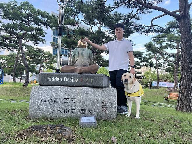 경북대는 오는 23일 열리는 학위수여식에서 시각장애인 김경훈 씨(32)의 학업을 도운 안내견 '탱고'에게 명예졸업증을 수여한다. 사진은 김 씨와 탱고. (경북대 제공)/뉴스1