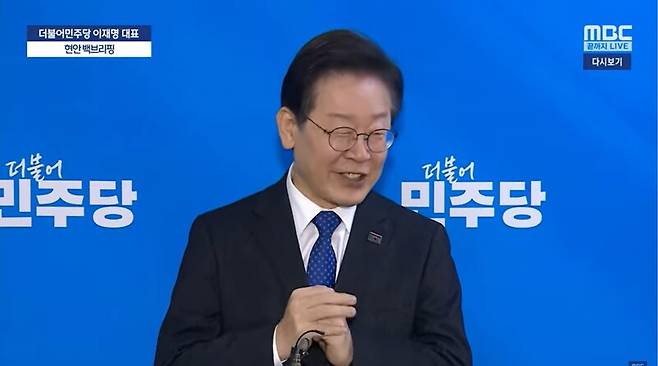 ▲이재명 더불어민주당 대표가 지난 22일 국회 본관 당대표 회의실 앞에서 연 현안 백브리핑에서 하위 20% 받은 의원과 관련해 의원 평가가 0점인 의원도 있다고 말하면서 웃고 있다. 사진=MBC 영상 갈무리