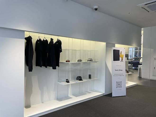 고객 대기실 한쪽 벽면엔 의류와 자동차 다이캐스트 등 테슬라 굿즈를 전시했다. /백수전 기자