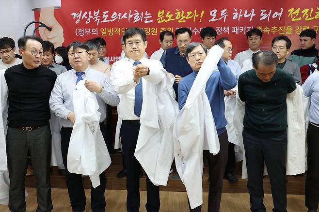경북도의사회 이우석 회장 등 도의사회 소속 의사들이 지난 15일 오후 7시 경북도의사회관에서 정부의 의대 정원 확대 정책에 반발하는 규탄대회를 열고 의사가운 탈의식을 진행하고 있다. [연합]