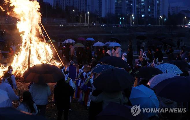 우산 쓰고 강강술래 (전주=연합뉴스) 나보배 기자 = 정월대보름인 24일 전북 전주시 완산구 삼천동 전주기접놀이전수관 인근에서 열린 정월대보름 굿 '망월이야' 행사에서 시민들의 소원지를 매단 달집태우기가 펼쳐지고 있다. 2024.2.24 warm@yna.co.kr