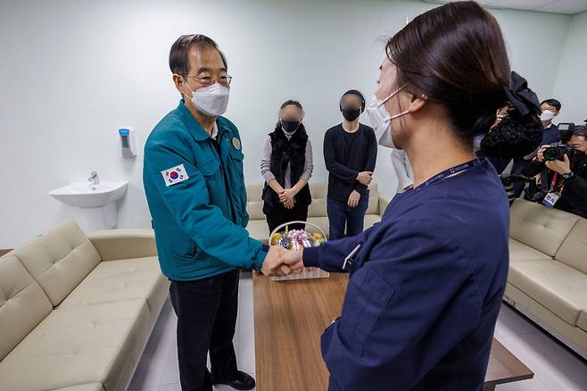 한덕수 국무총리가 25일 경기 성남시 국군수도병원을 방문해, 민간 병원에서 입원할 곳을 찾지 못한 중환자가 군병원으로 와 치료받을 수 있게 도운 간호사를 격려하고 있다. /연합뉴스