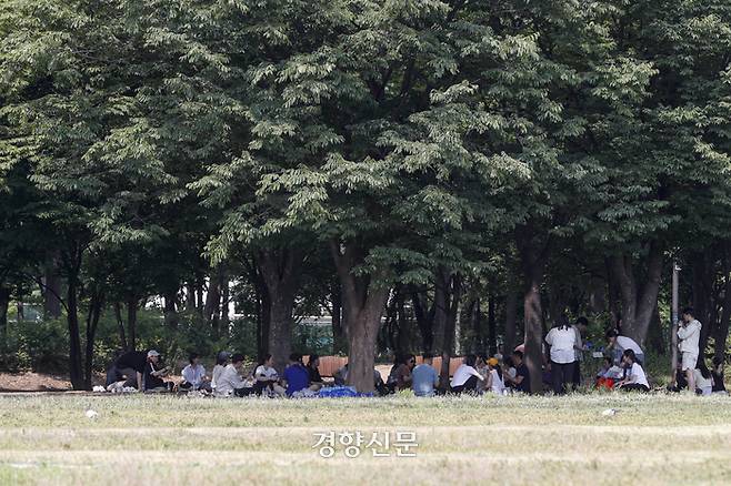 서울의 한낮 기온이 34도로 폭염특보가 발효됐던 지난해 6월 19일 서울 성동구 서울숲에서 시민들이 나무 그늘에 앉아 더위를 피하고 있다. 문재원 기자
