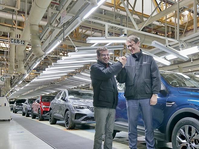 Renault Korea Motors CEO Stephane Deblaise and French Ambassador Philippe Bertoux exchange a friendly handshake at the XM3 assembly line during the ambassador's visit to the Busan plant on Friday. (Renault Korea Motors)