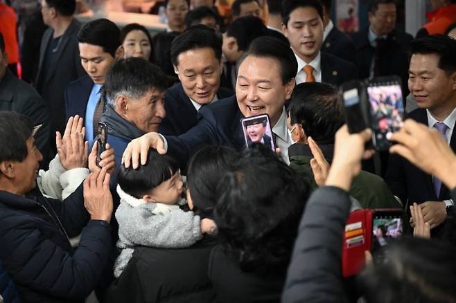 윤석열 대통령이 26일 충남 서산 동부 전통시장을 방문해 시민, 상인들과 인사하고 있다. [이미지출처=연합뉴스]