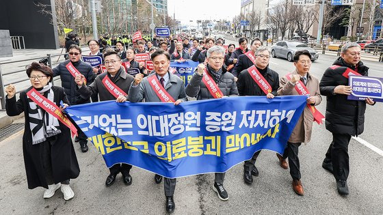 25일 오후 서울 용산구 대한의사협회에서 열린 '전국 의사 대표자 확대 회의 및 행진 행사'에서 참가자들이 대통령실 방향으로 행진하며 의대 정원 증원 반대 구호를 외치고 있다. 연합뉴스