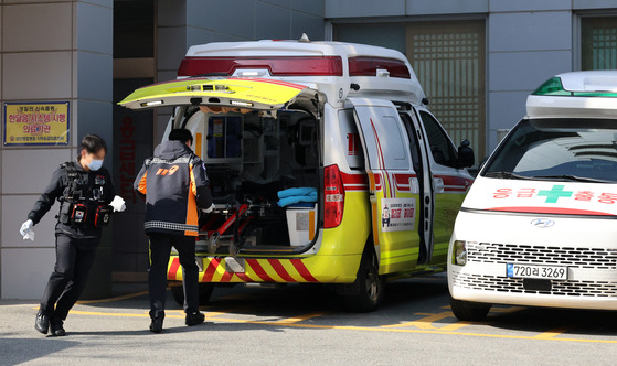 Paramedics handle a patient in front of an emergency room at a secondary hospital in Gwangju on Monday. [YONHAP]