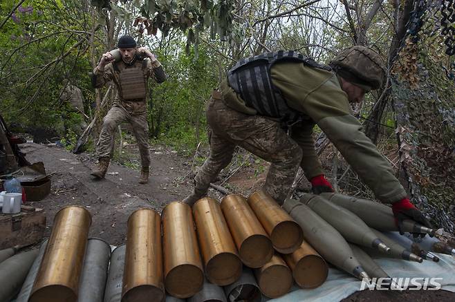 [차시우 야르=AP/뉴시스] 11일(현지시간) 우크라이나 도네츠크주, 러시아군과의 격전지인 차시우 야르에서 우크라이나 군인들이 자주포 발사를 위해 포탄을 준비하고 있다. 2023.05.12.