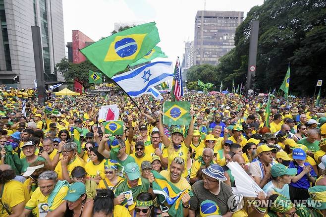 브라질·이스라엘 국기 흔드는 보우소나루 지지자들 (상파울루 AP=연합뉴스) 25일(현지시간) 브라질 상파울루에서 열린 집회에서 자이르 보우소나루 전 대통령 지지자들이 브라질·이스라엘 국기를 흔들고 있다. 2024.2.26
