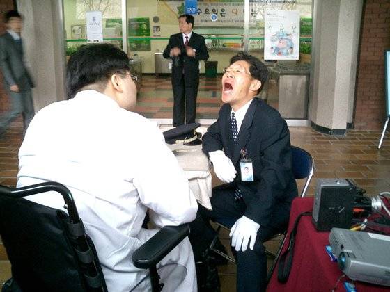 전신 마비지만 앉아만 있으면 건강이 악화하기에 집에서 매일 기구를 이용해 한 시간씩 서 있는다. 처음엔 서 있는 것만으로도 기절할 정도로 어려웠다. 세 끼 식사도 다 하면 안 되기에 저녁 한 끼 정도만 제대로 챙겨 먹는다. 그래도 환자는 최고로 진료한다. [사진 이규환]