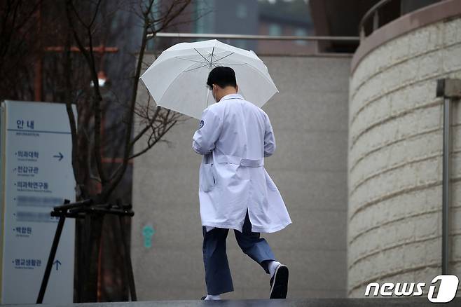정부가 의대 정원 확대에 반발하며 의료 현장을 떠난 전공의들에게 제시한 복귀 시한 마지막 날인 29일 대구의 한 대학병원에서 우산을 쓴 의료진이 발걸음을 옮기고 있다. 2024.2.29/뉴스1 ⓒ News1 공정식 기자
