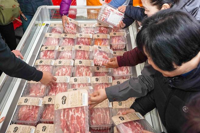 지난달 29일 서울 종로구에서 열린 '3.3 한돈 삼겹살데이, 국돼가 국룰' 행사에서 시민들이 고기를 집어들고 있다./뉴시스