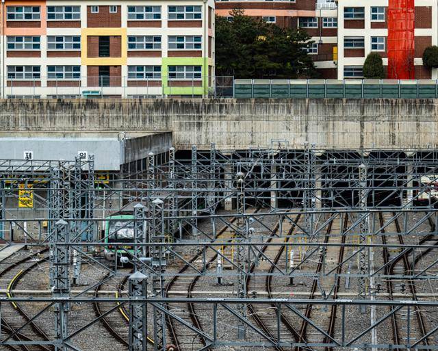 신정차량기지 위에는 양천아파트 외에 초등학교도 함께 건설됐다. 지난달 27일 서울 양천구 신정차량기지 위에 지어진 초등학교 아래로 전동차가 지나고 있다.